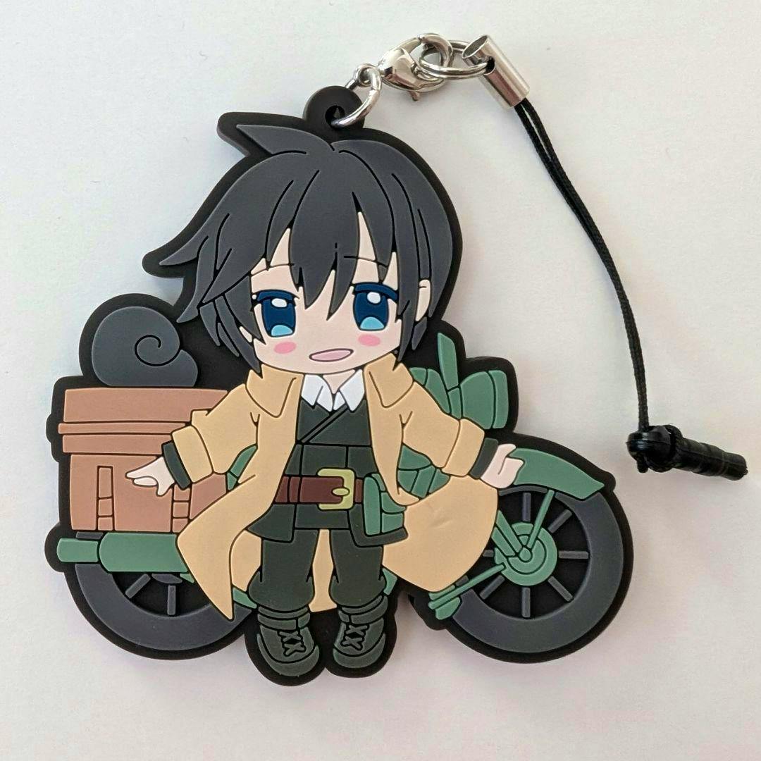 Front of the rubber keychain strap featuring a chibi-style Kino character in a tan coat standing in front of a motorcycle with a black cord strap attached.