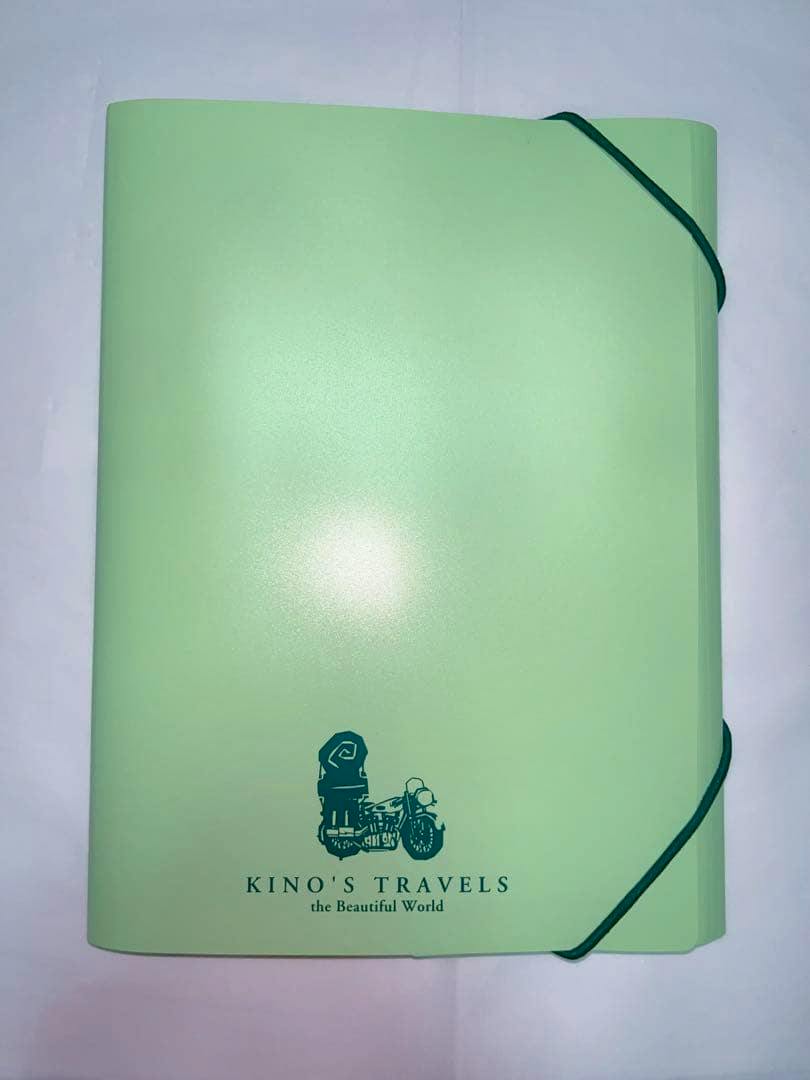 Light green letter-set folder with elastic corner straps and a 'KINO'S TRAVELS' motorcycle logo on the front.