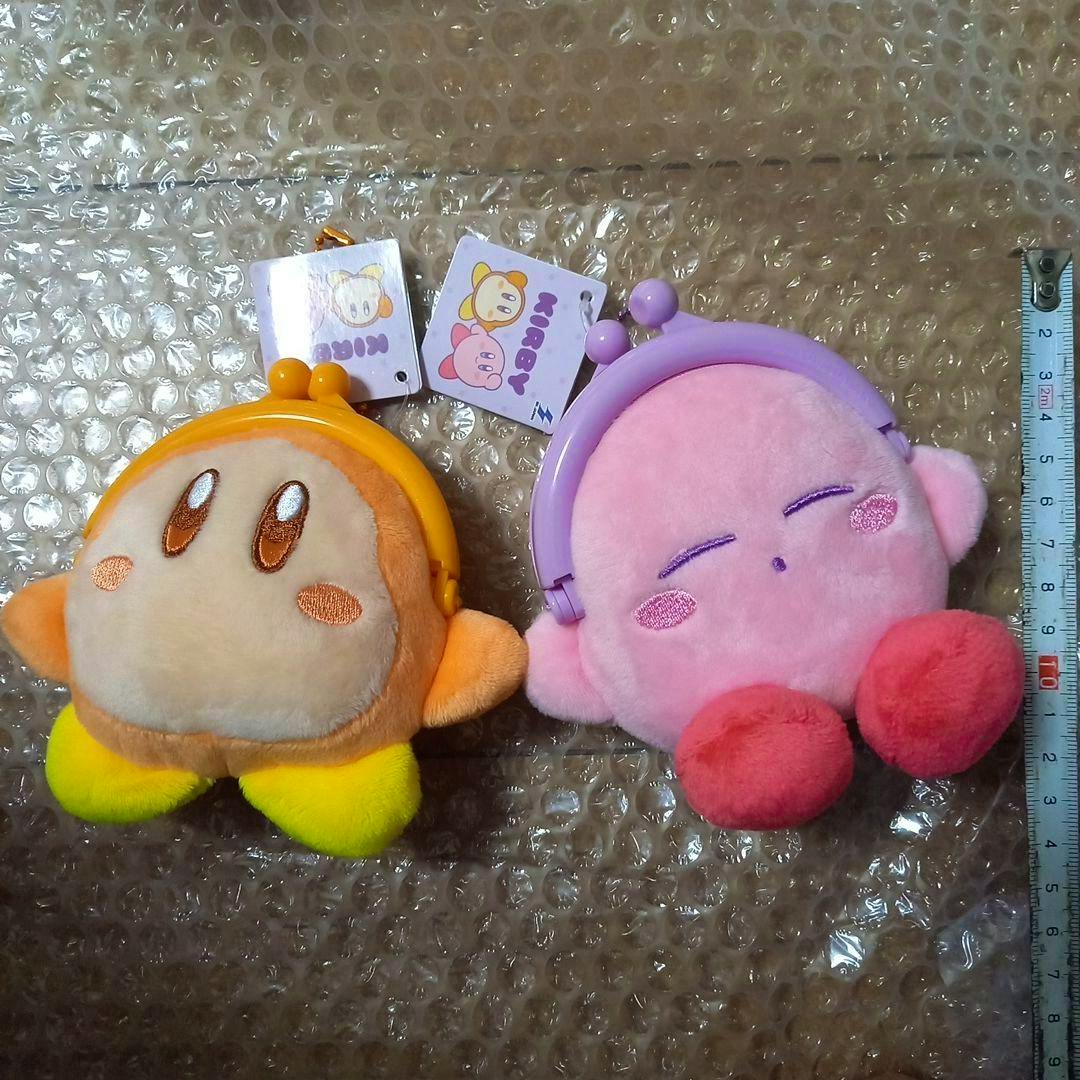Front view of two plush coin purses shaped like Kirby (pink) and Waddle Dee (orange) with kiss‑lock clasps on bubble wrap.