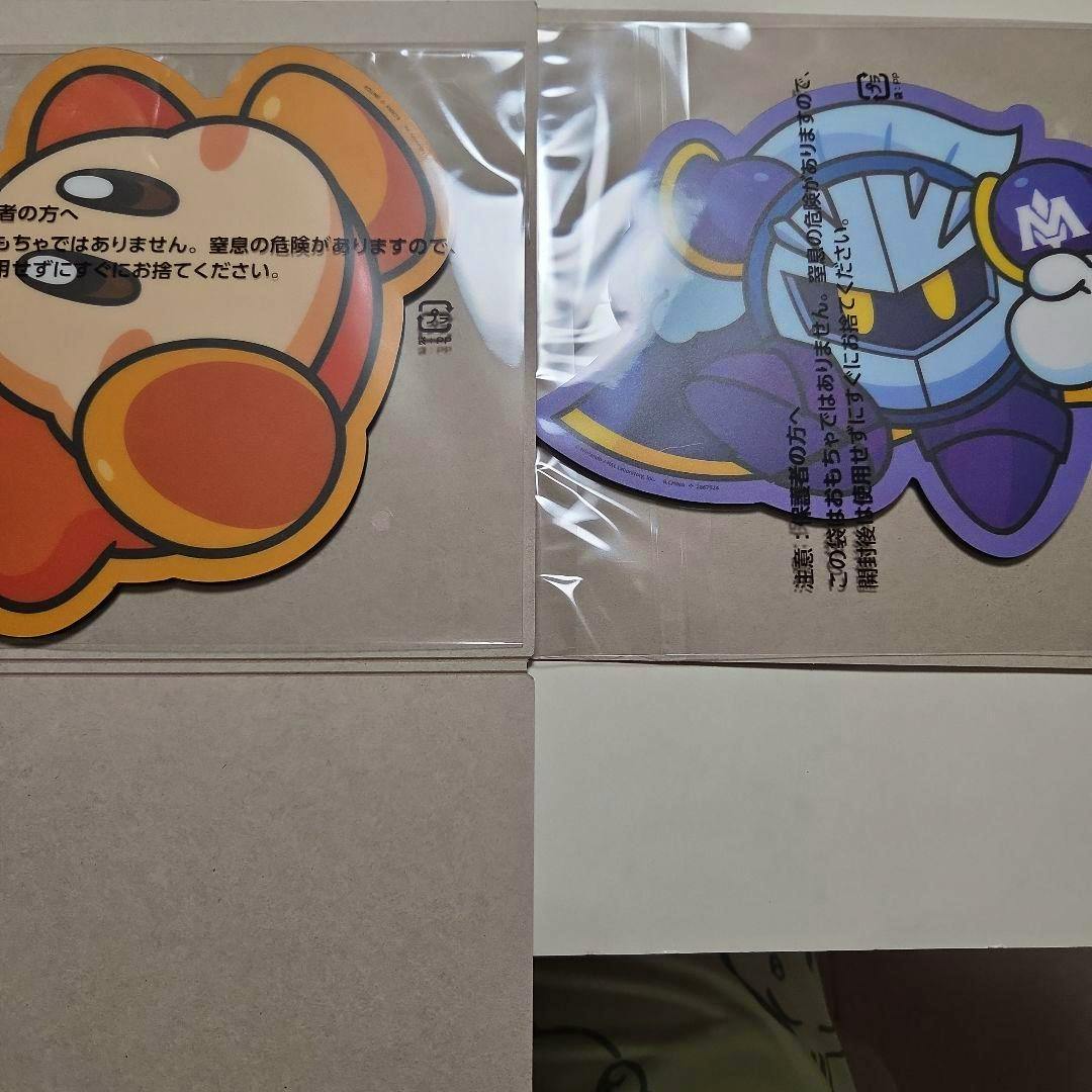 Two Kirby-themed mouse sheets (one orange Kirby and one Meta Knight) in clear plastic packaging, shown side by side.