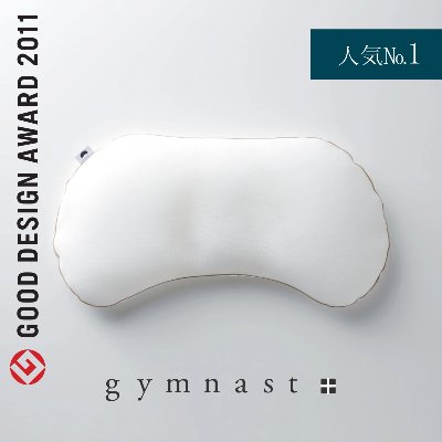 White curved pillow (gymnast) photographed on a light background with brand text and award badge.