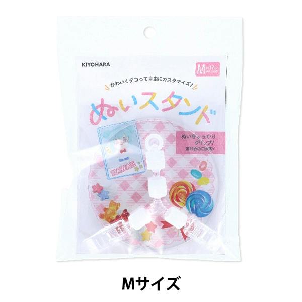 Retail package showing KIYOHARA ぬいスタンド Mサイズ plastic stand parts visible inside the clear packaging.