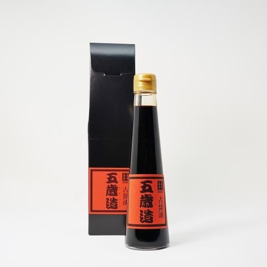 A 200ml soy sauce bottle with a red label standing in front of a black box.