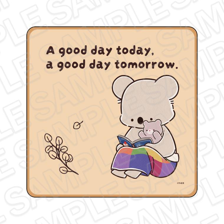 Square die-cut mini towel featuring a koala character reading a book with the text "A good day today, a good day tomorrow."