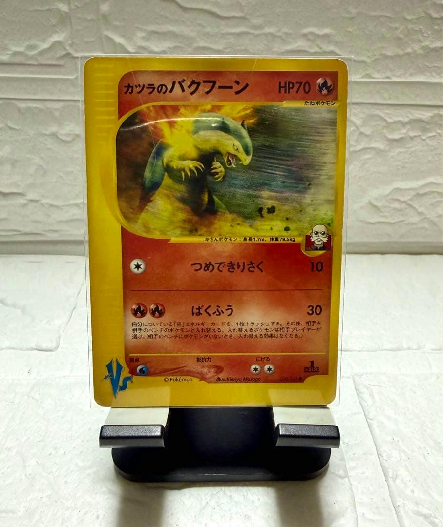 Front of the カツラのバクフーン Pokémon trading card displayed upright on a stand showing the card's artwork and Japanese text.