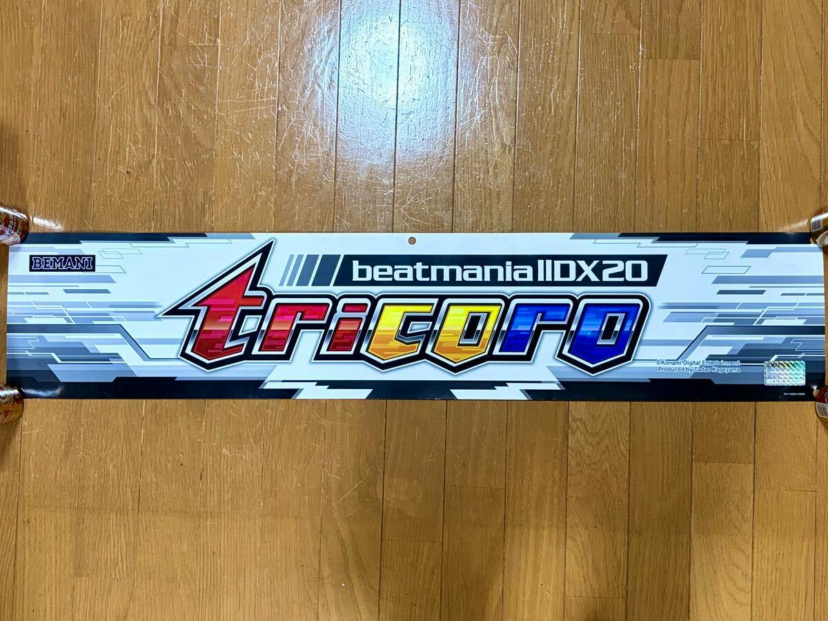 Front of a Beatmania IIDX 20 tricoro marquee/poster showing the colorful "tricoro" logo and game branding.