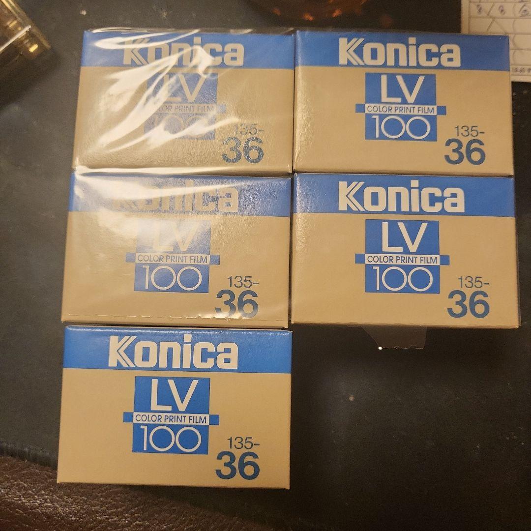 Five boxed Konica LV 100 color print film (135-36) rolls arranged on a surface.