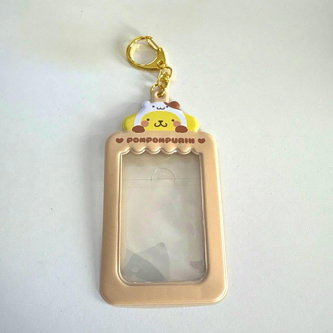 Beige plastic PomPomPurin card case with a clear front window, character topper, and a gold keyring.