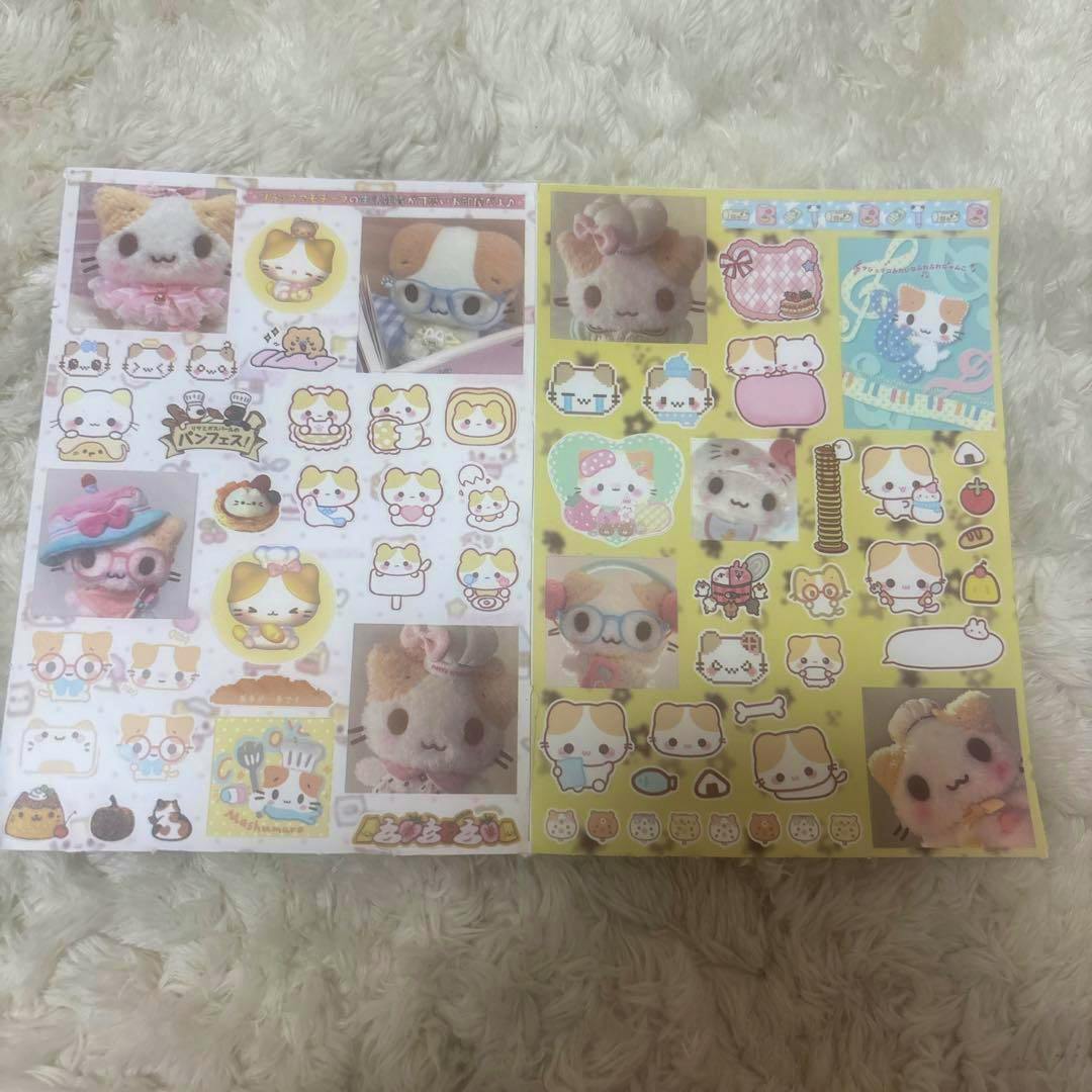 Photo of two paper sticker sheets featuring cute cat-themed kawaii illustrations on a fluffy background.