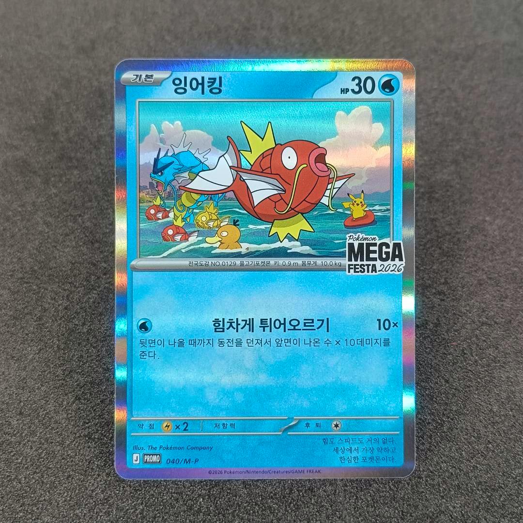 Front of the 韓国限定 MEGA FESTA 2026 コイキング 040/M-P プロモ trading card showing the holographic front artwork on a gray surface.