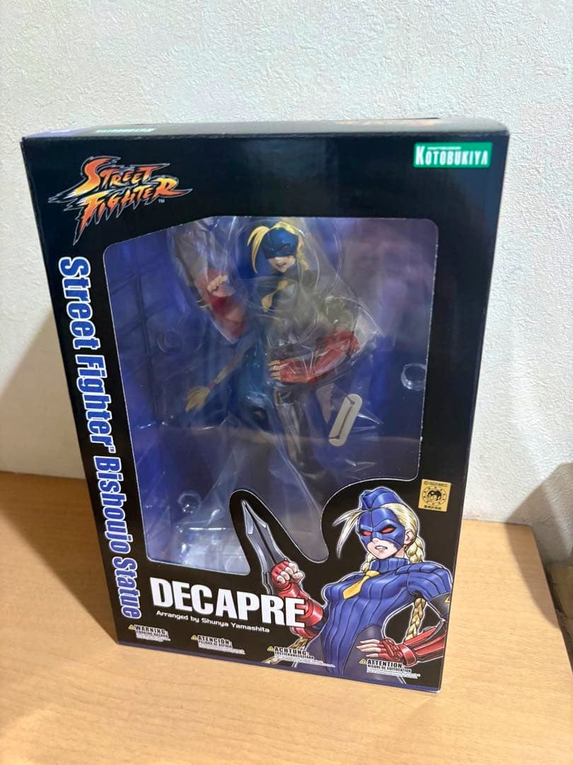 Front view of the unopened Kotobukiya Street Fighter Bishoujo Decapre figure in its original box, showing the figure through the window.