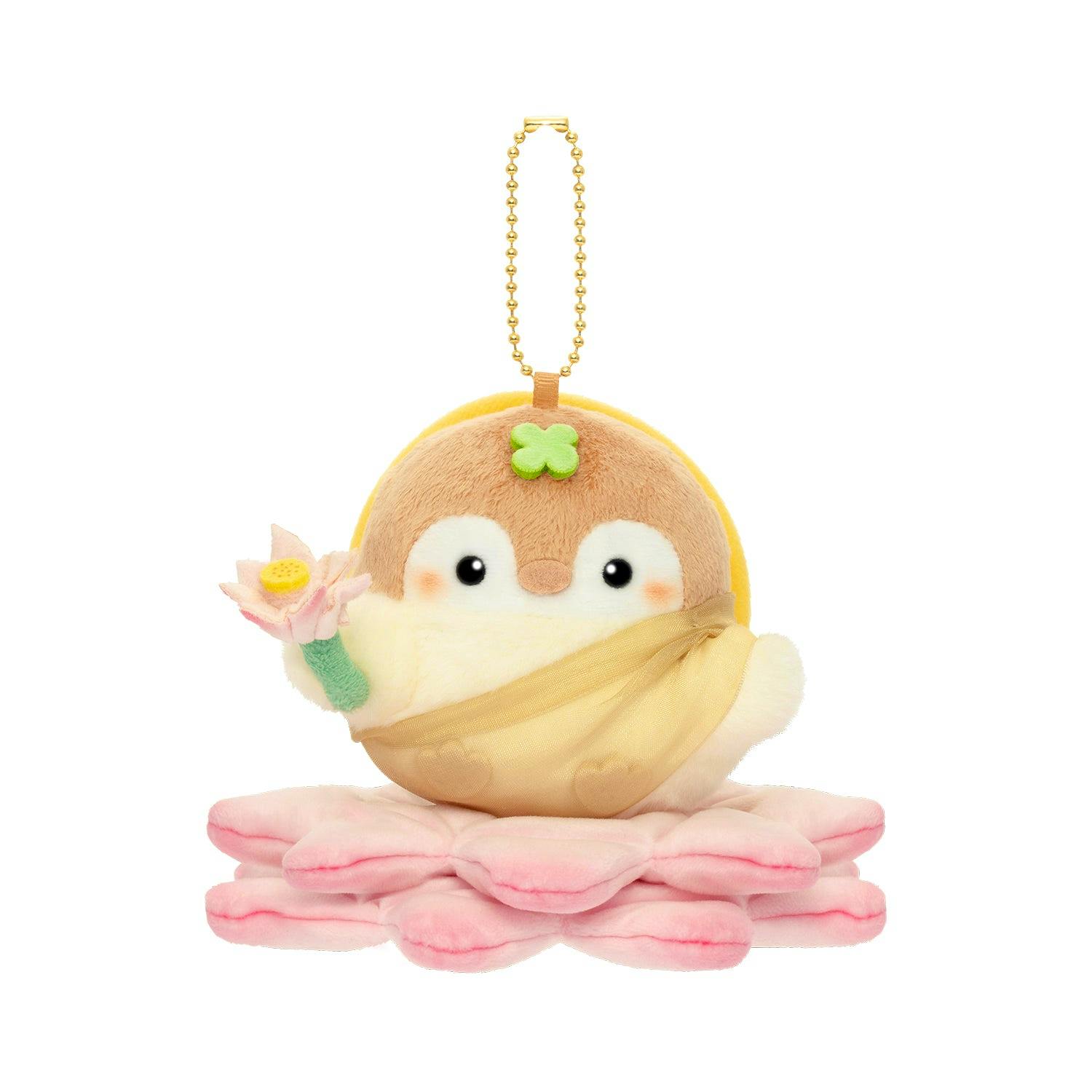 Front view of the コウペンちゃん 仏様コウペンちゃんマスコット plush keychain resting on pink layered petals with a gold ball chain attached.