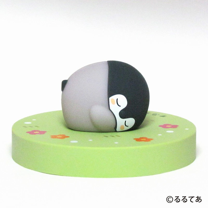 A Koupen-chan desktop LED table lamp shaped like a sleeping penguin on a round green floral base.