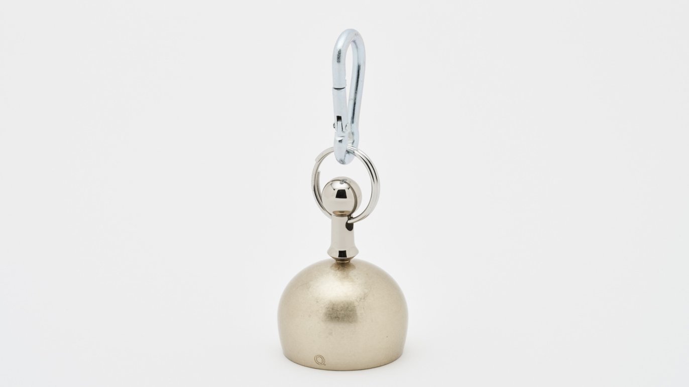 Small bicycle bell with a metal clip and keyring shown against a white background.