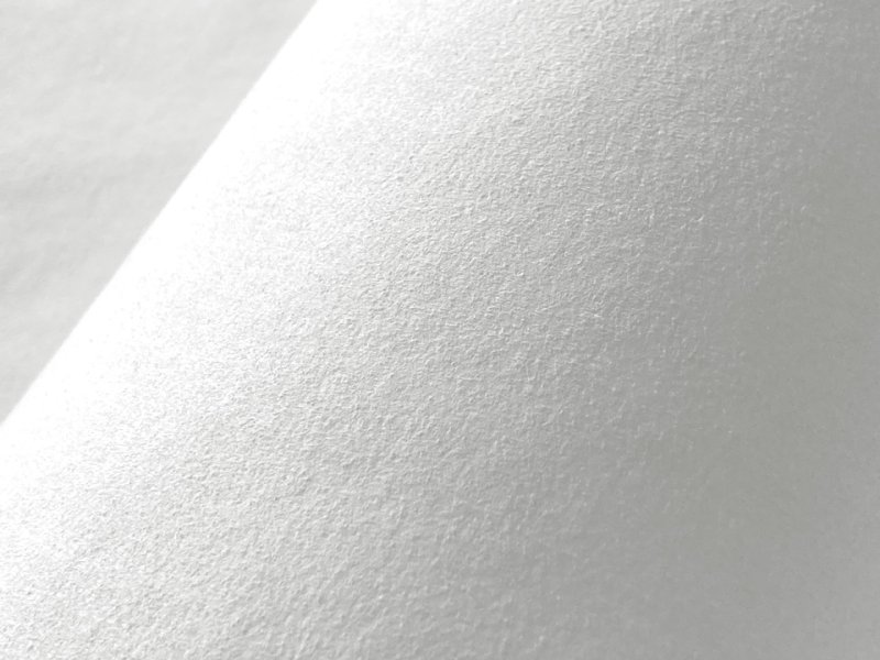 Close-up of white Clarino suede-like artificial leather fabric showing its texture.
