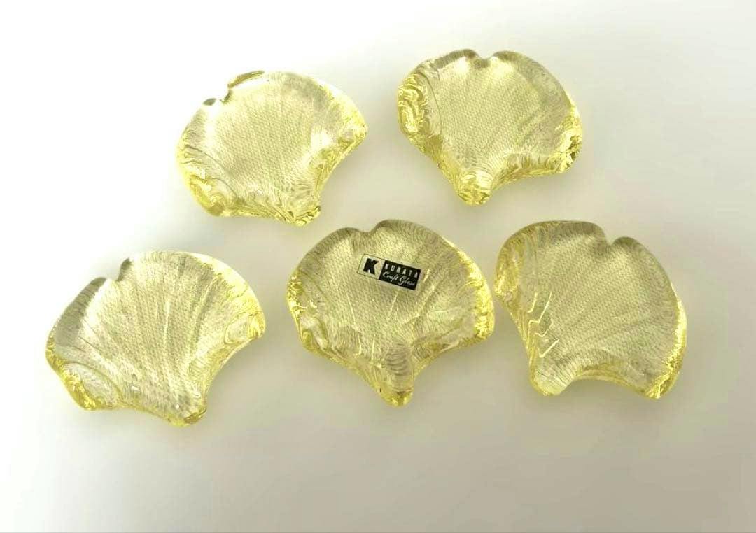 Five yellow glass ginkgo-leaf chopstick rests displayed on a white background.