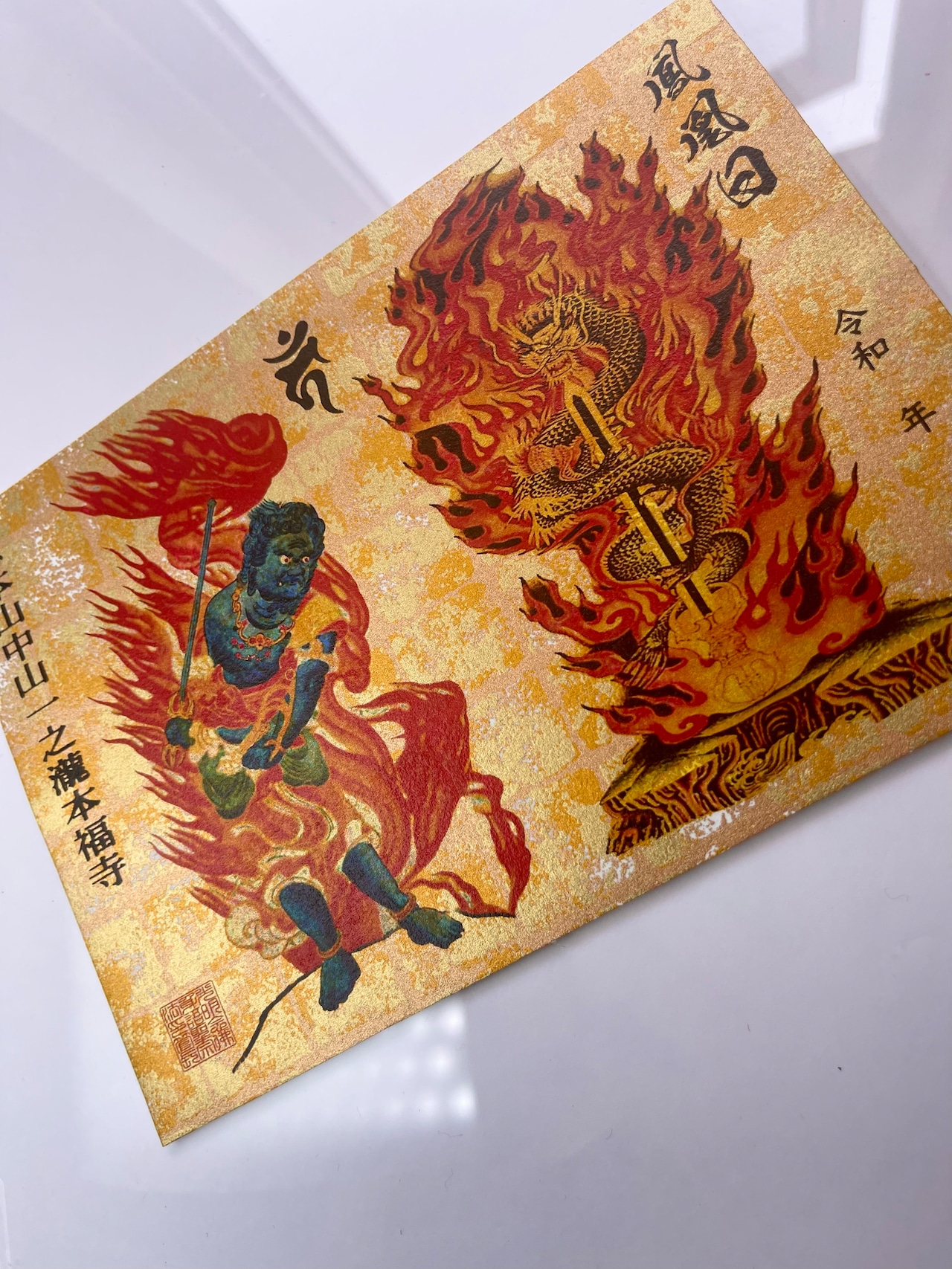 Photo of the greeting card showing Kurikara Fudō-son artwork on gold-flecked dyed washi paper.