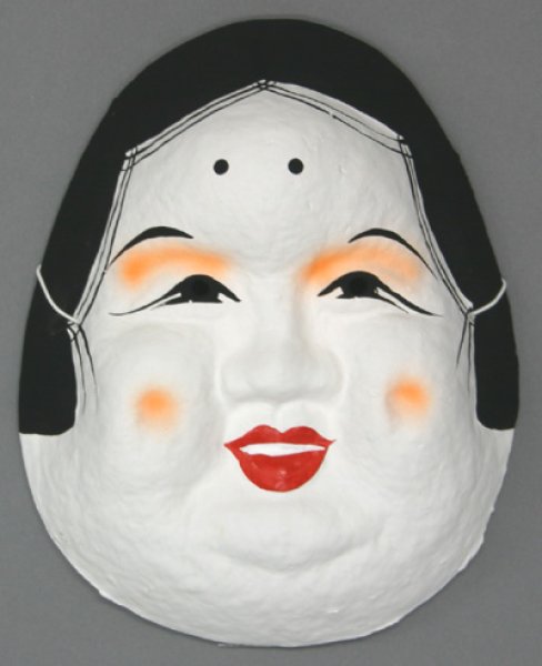 Front view of a wooden Japanese Noh mask (Okame) with a white face, black hair, red lips, and orange blush on the cheeks and eyelids.