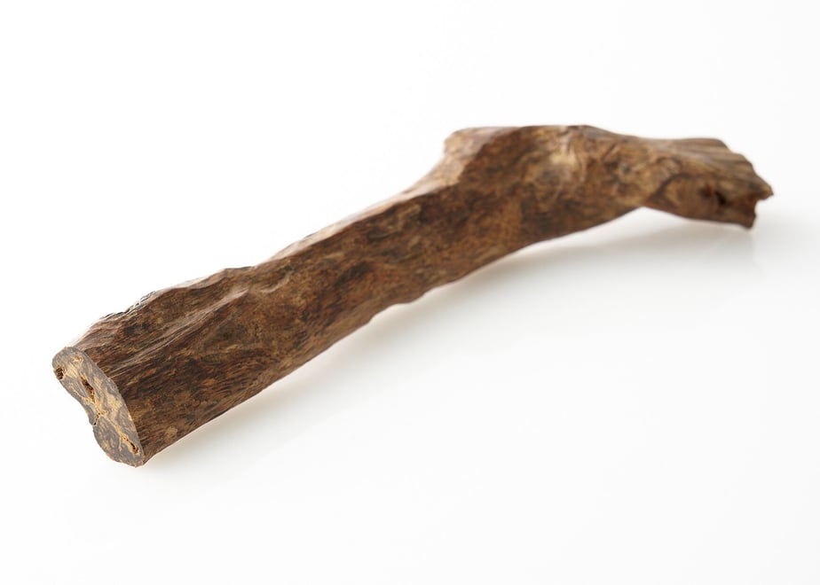 Close-up photo of a single piece of agarwood (沈香) incense on a white background.
