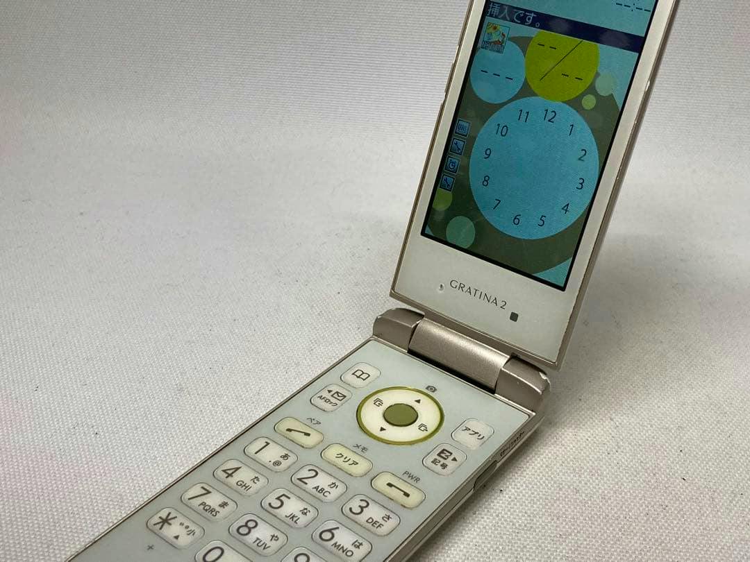 Open au KYY10 GRATINA2 flip mobile phone showing its display and numeric keypad.