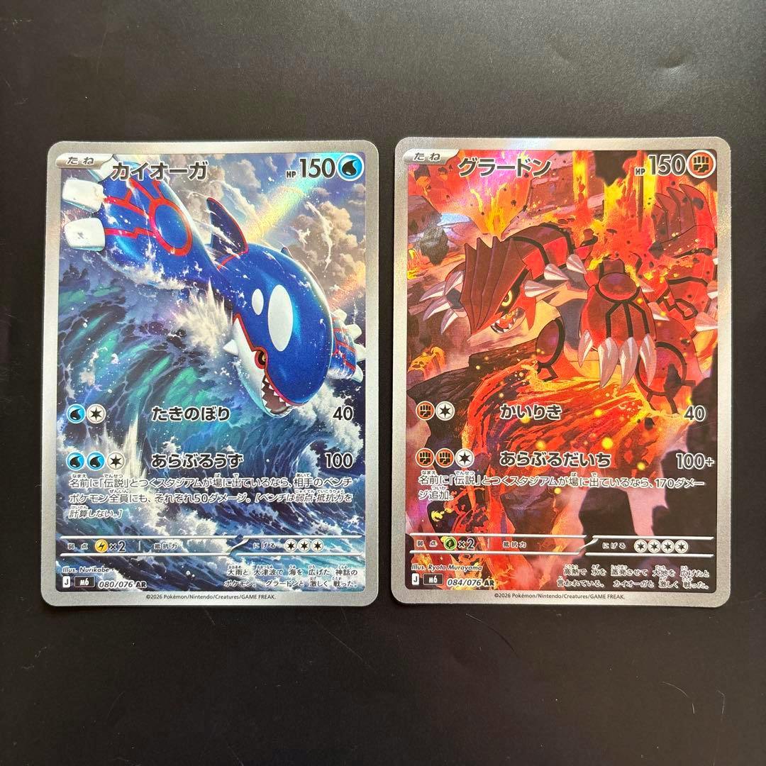 Fronts of two Pokémon trading cards shown side by side, Kyogre (left) and Groudon (right).