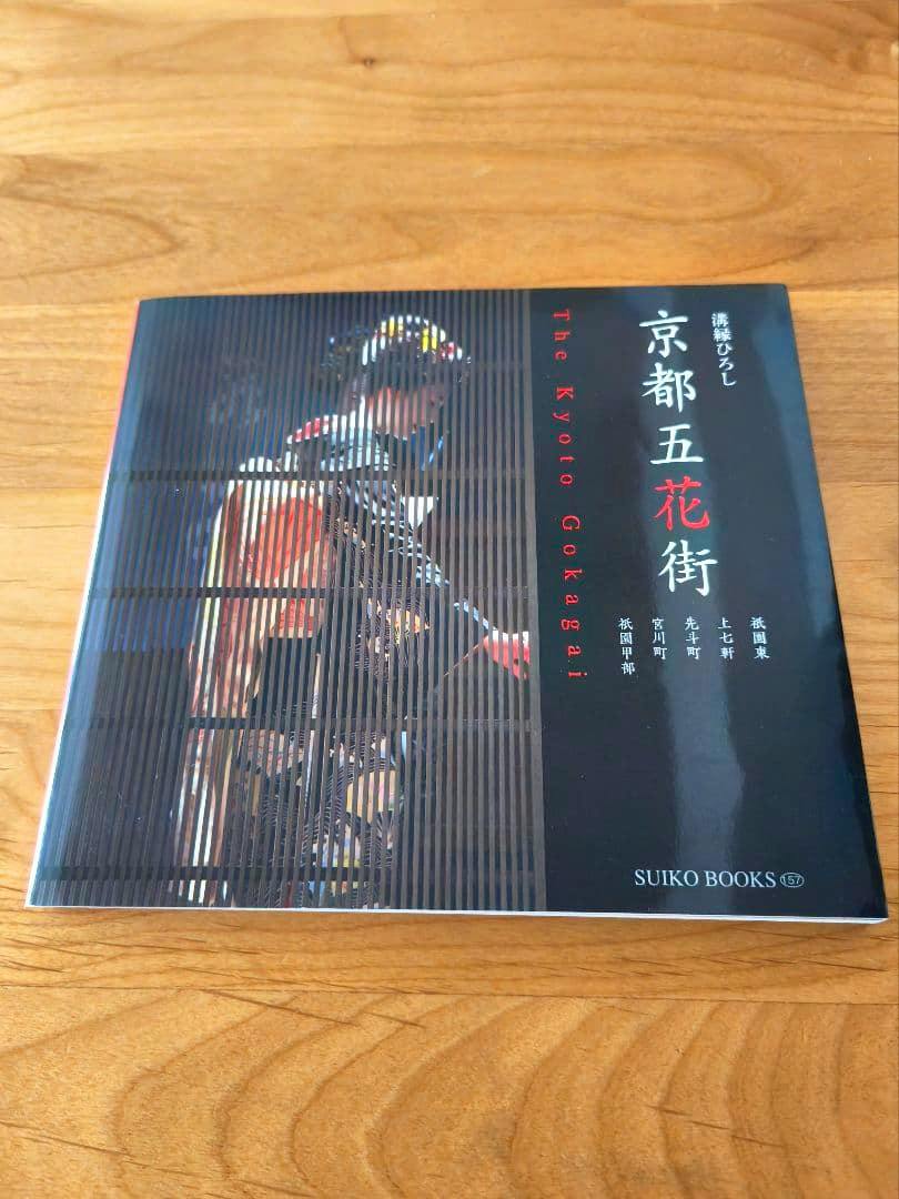 Front cover of the book '京都五花街 写真集 講談社' showing a vertical striped overlay image of a person and Japanese text on a black background.
