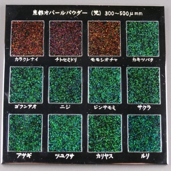 Display board showing twelve square swatches of coarse Kyoto opal powder (300–500 μm) in various colors with Japanese labels.