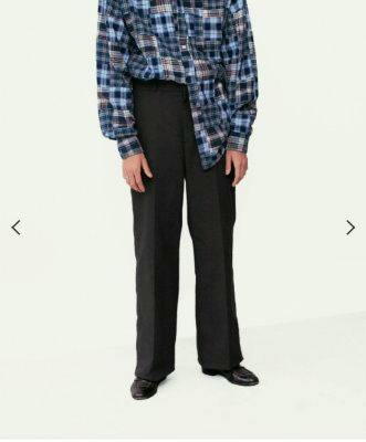 Full-length front view of a model wearing the men's chino pants paired with a plaid shirt.
