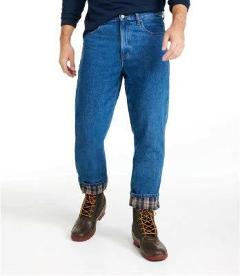 Front view of men's classic-fit blue jeans rolled to show the flannel lining, worn by a model with boots.