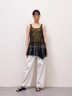 Model wearing the black lace asymmetrical-hem tunic styled over another top and pants.