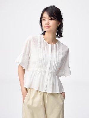Woman modeling the white lace-frilled blouse from the product listing.