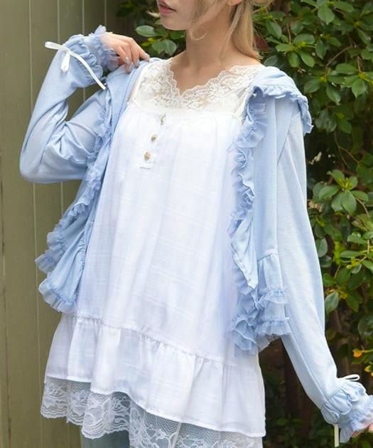 Model wearing a white lace-hem camisole tunic layered under a light blue ruffled cardigan.