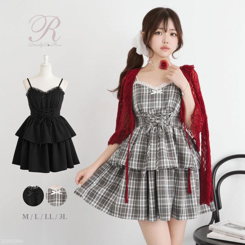 A model wearing a plaid tiered camisole dress stands beside a mannequin displaying the same dress in black.