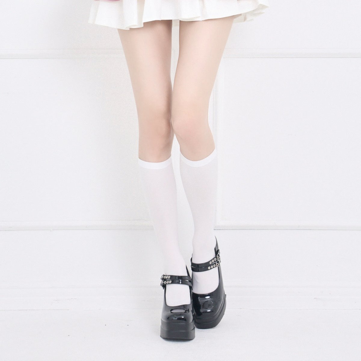 White 60-denier knee-high socks worn by a model, shown from knees to shoes.