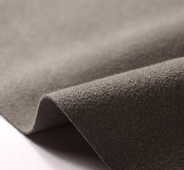 A gray soft-pile polyester fabric sample folded to show the pile texture.