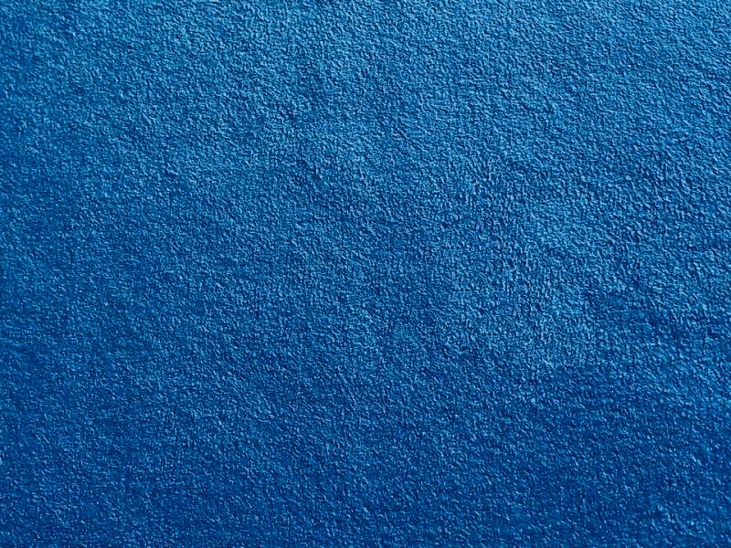 Close-up of blue suede-like polyester fabric showing the textured nap and surface.