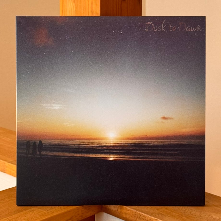 Front cover of the Lamp LP record showing a sunset over the ocean on a square vinyl jacket.