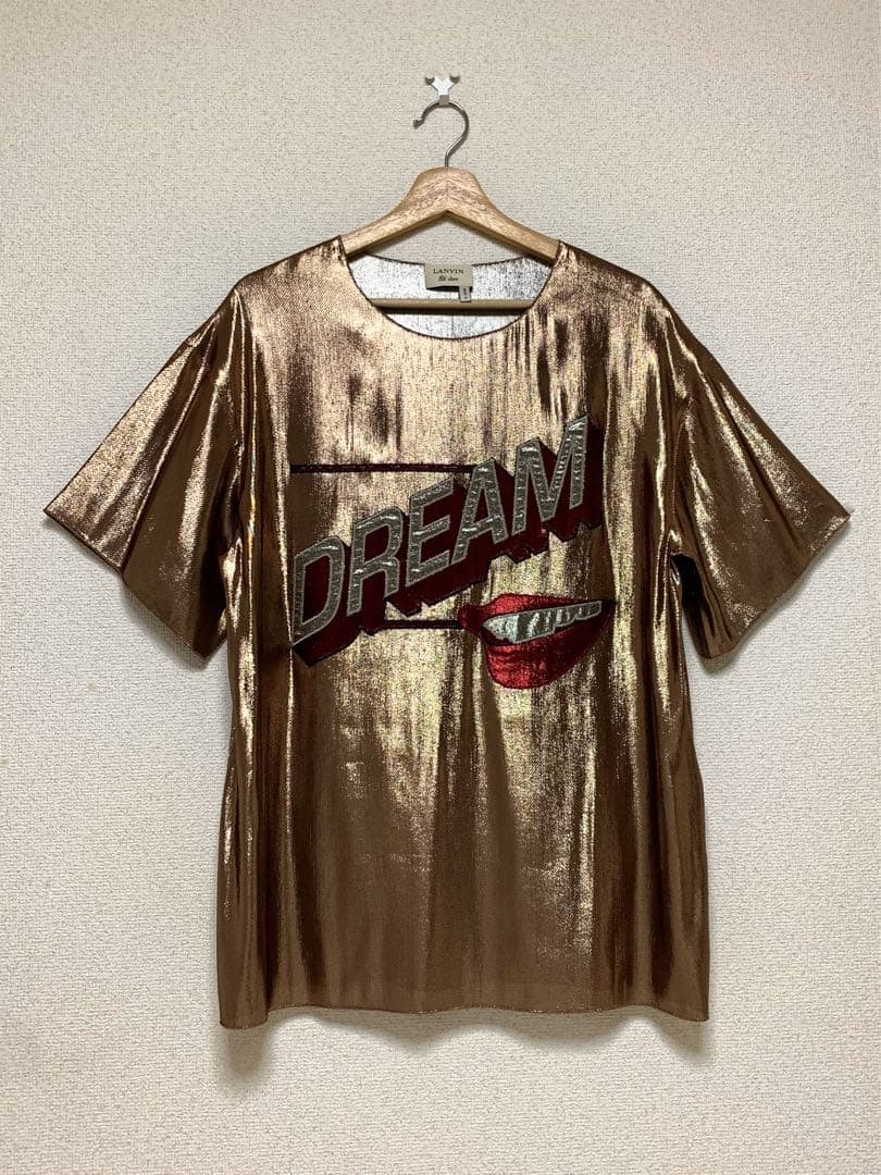 Front view of a men's metallic gold Lanvin T‑shirt on a hanger showing a large "DREAM" graphic and lips motif.