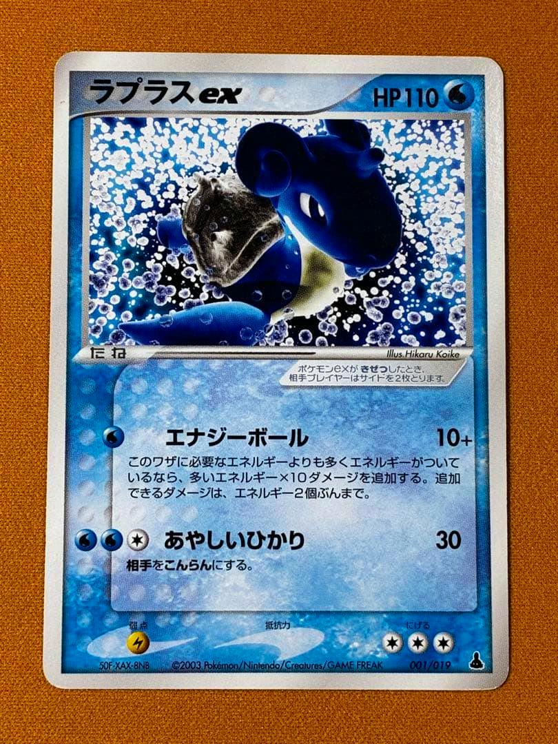 Front-view photograph of the ラプラスex ミズゴロウ trading card (001/019) showing the full card artwork, Japanese text, and HP110.