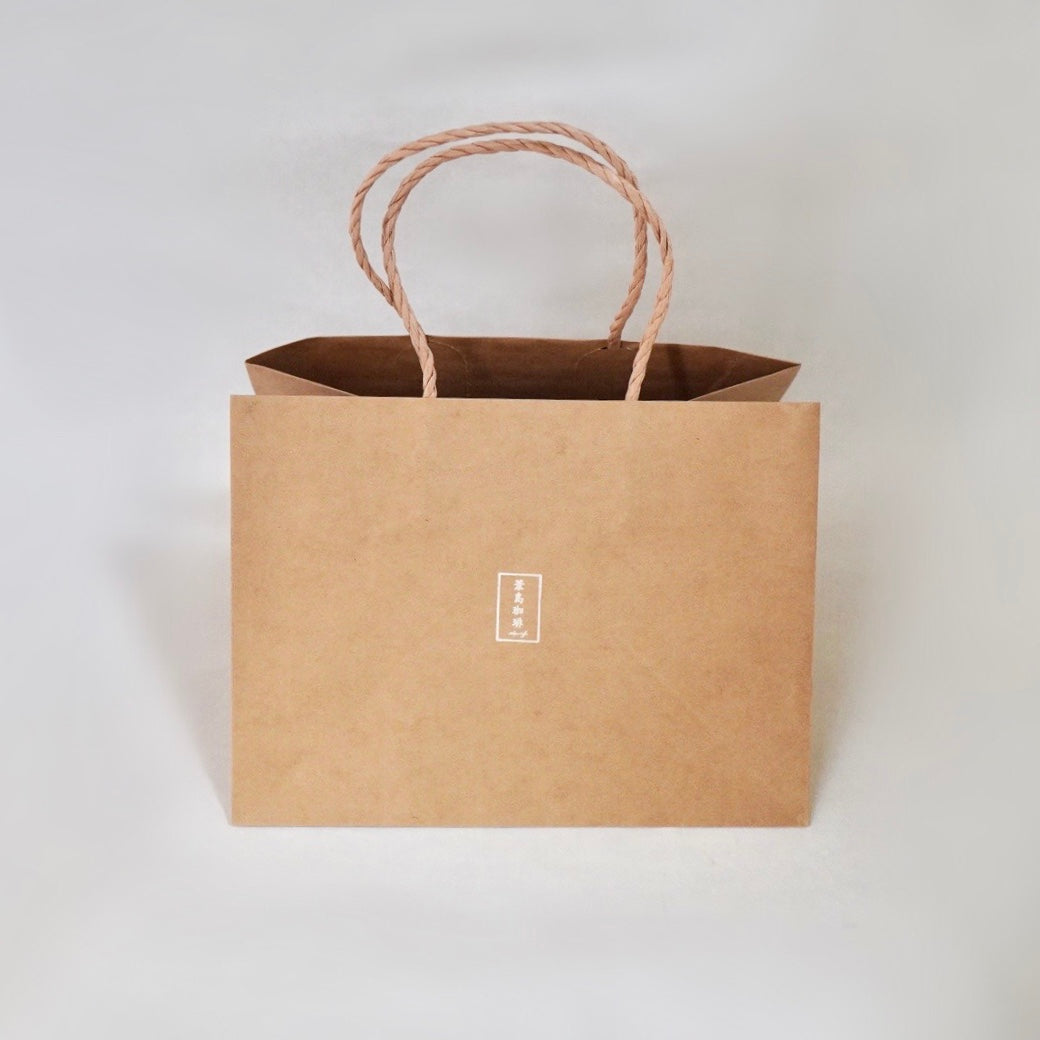 A large brown paper bag with twisted handles and a small centered logo on the front.