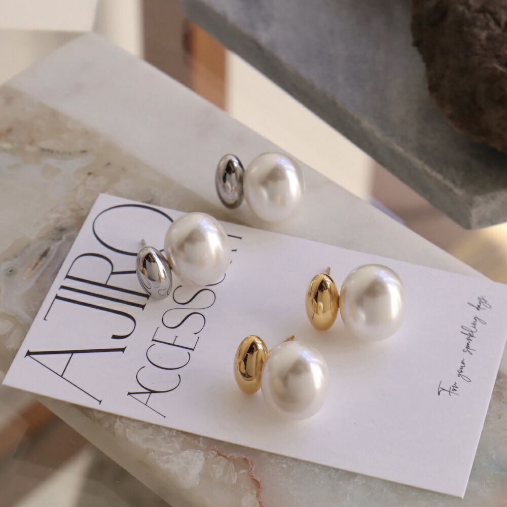 Two pairs of large pearl earrings with silver and gold metal backs shown on a white accessory card.
