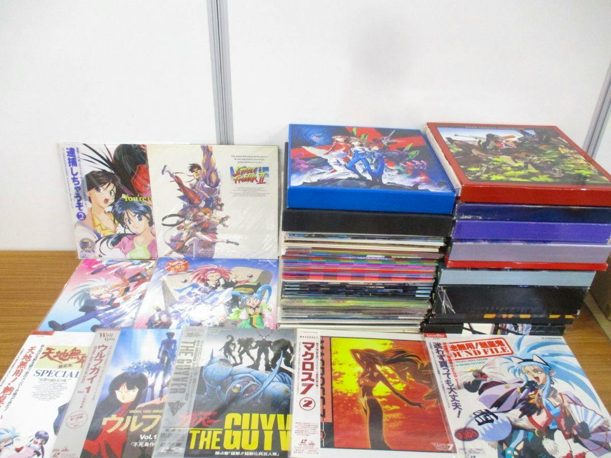 Photo of many anime LaserDisc covers and boxed sets stacked on a table, shown as a large lot for sale.