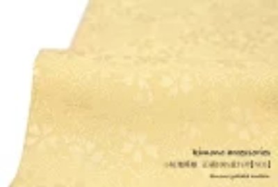 Folded yellow patterned fabric shown for 重ね衿 (kasane-eri) on a white background.