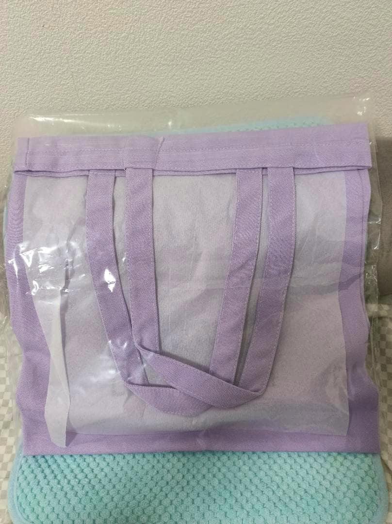 Light purple tote bag (LE SSERAFIM × MY MELODY&KUROMI) shown from the back with handles, inside plastic packaging.