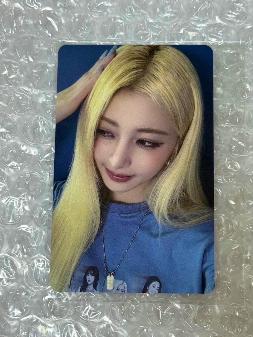 Front of the photocard showing a close-up portrait of a blonde woman in a blue shirt placed on bubble wrap.