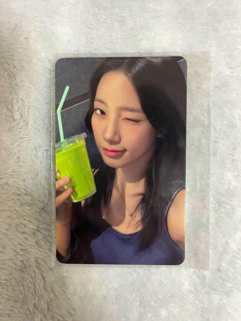 Front of the photocard showing a woman winking and holding a bright green drink.
