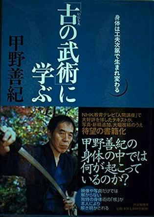 Book cover showing Japanese title text on a blue background and a photograph of a man holding a sword.