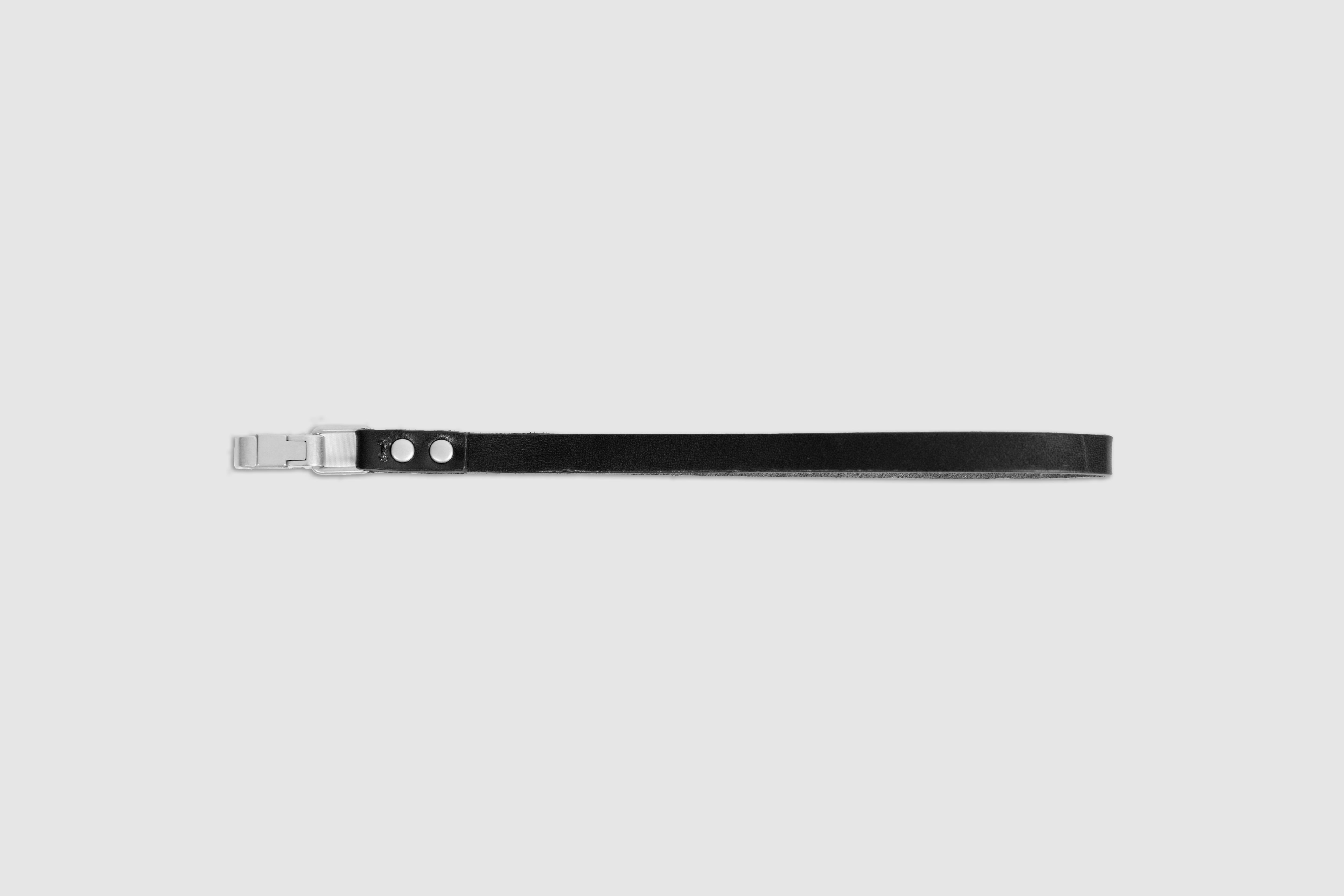 A black cow-leather hand strap with silver metal hardware laid flat on a light background.