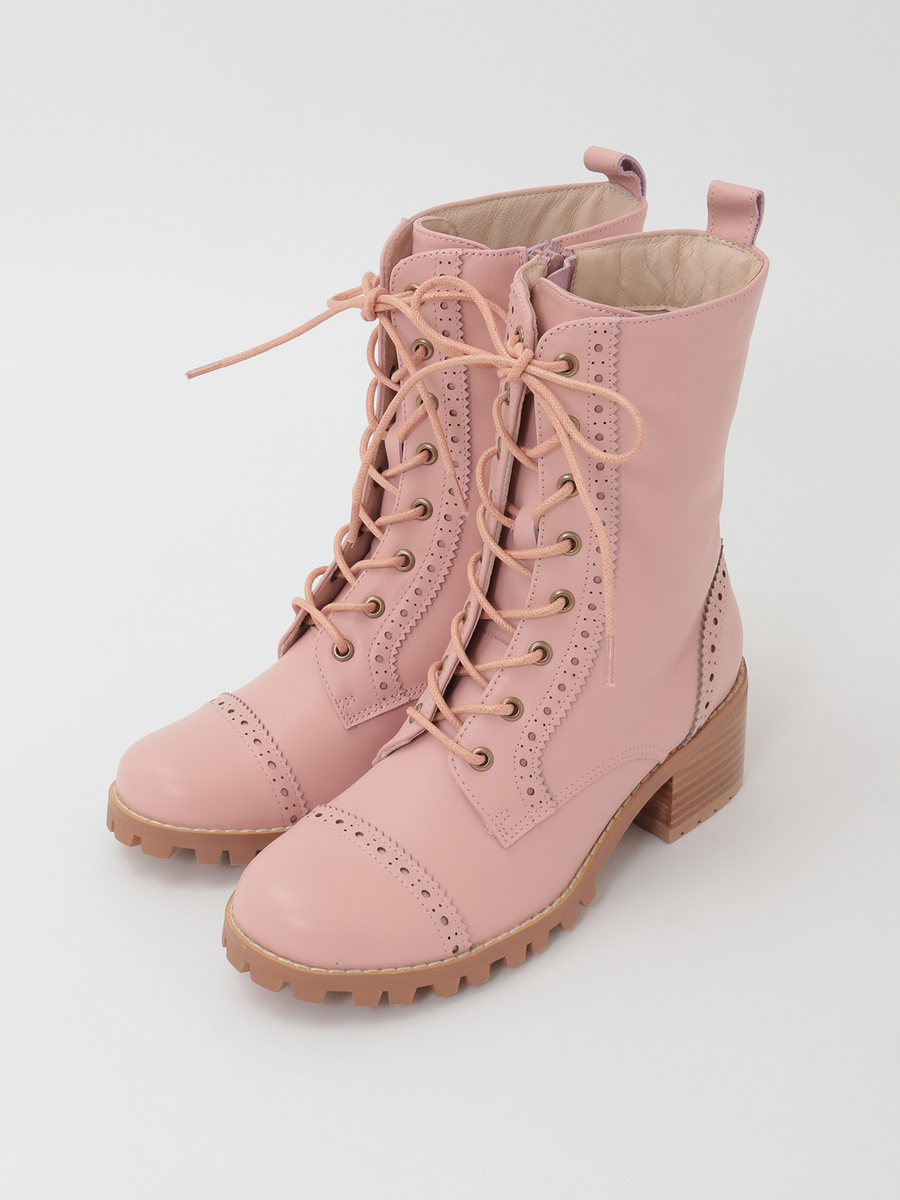Pair of pink lace-up leather boots with a lug sole and low block heel on a white background.