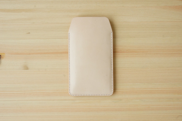 Natural cow leather iPhone sleeve case placed flat on a wooden surface.